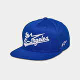 Alpinestars Los Angeles pet, snapback cap met platte klep, blauw met wit 3D geborduurd 'Los Angeles' atletisch lettertype, Ageless-logo aan de zijkant, gestructureerde kroon, casual motorsport-geïnspireerde headwear