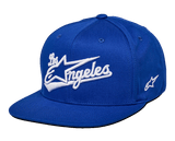 Alpinestars Los Angeles pet, blauwe snapback cap, wit 3D-geborduurd Los Angeles-logo in atletisch lettertype, platte klep, gestructureerde kroon, casual motorsport-geïnspireerde hoofdbedekking