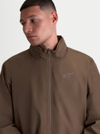 Alpinestars Overhaul Racer jas, lichtgewicht herensportswearjas, bruin, motorsportgeïnspireerd ontwerp met hoge kraag, verborgen capuchon en klein HD-print logo op de borst.