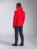 Alpinestars Frontal Hoodie, rode pullover fleece hoodie, achteraanzicht met wit woordmerklogo op de mouw, gedragen met donkere denim broek en zwarte schoenen, casual motorsport streetwear