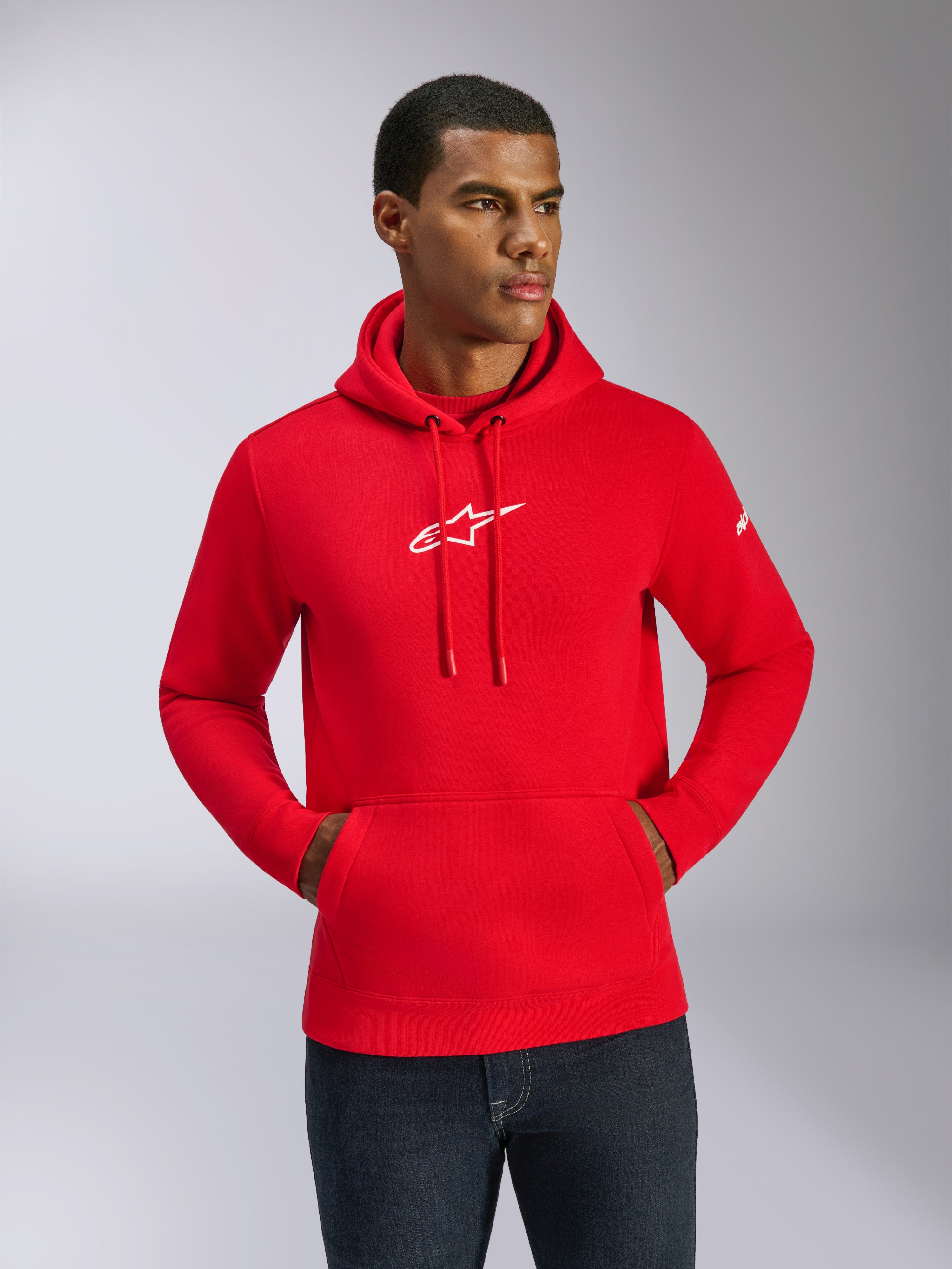 Alpinestars Frontal Hoodie, rood met wit logo, mannelijk model draagt pullover fleece met kangoeroezak en verstelbare trekkoorden, casual motorsport streetwear