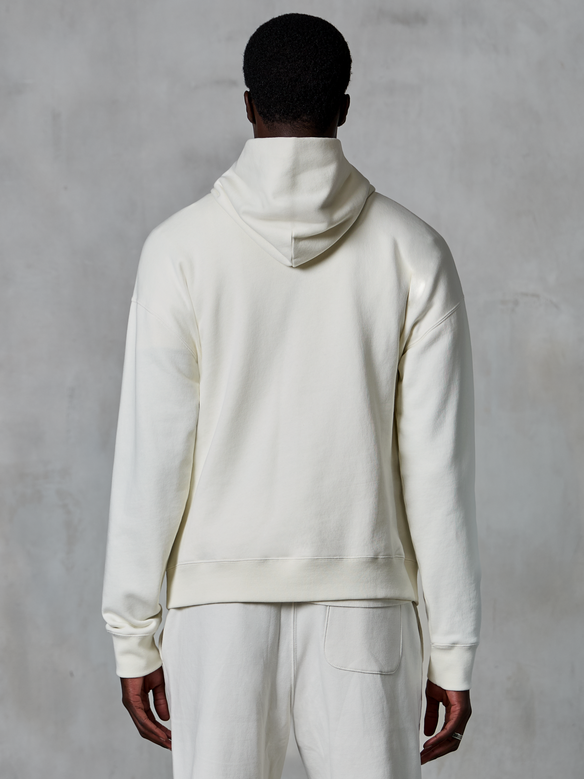 Alpinestars Essentials Ageless Hoodie, off-white pullover hoodie, back view on model, clean minimalist design, matching casual pants, relaxed fit for everyday comfort