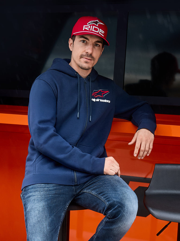 Alpinestars Formulation Hoodie, Navy Blue, Zip-Front Hoodie with Alpinestars logo on the chest, worn with a red cap and jeans, casual motorsport lifestyle streetwear