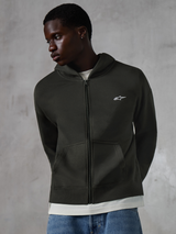 Alpinestars Essentials Ageless Zip Hoodie, Off Black casual streetwear, full-zip fleece featuring a small white Alpinestars logo on the chest, worn by a model with blue jeans, relaxed fit with front pockets and stone-washed finish.