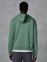 Alpinestars Essentials Ageless Zip Hoodie, achteraanzicht op model, Cactus groen, casual motorsport-geïnspireerde streetwear, relaxte pasvorm met geribbelde zoom en manchetten, hoogwaardige compacte fleece