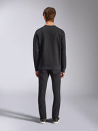 Alpinestars Bettern Crew, zwarte sweatshirt met ronde hals, achteraanzicht op model, geribbelde kraag en zoom, casual motorsport-geïnspireerde streetwear