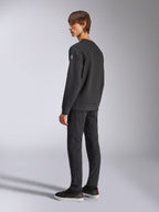 Alpinestars Bettern Crew, fleece pullover, zwart, mannelijk model getoond vanuit een achter- en zijaanzicht, voorzien van geribbelde manchetten en zoom met een klein logo op de mouw, casual motorsport-geïnspireerde streetwear