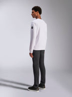 Alpinestars Bettern Crew, witte crewneck sweatshirt, achter- en zijaanzicht, zwart cirkelvormig logo op de mouw, gedragen met een donkergrijze broek en zwarte sneakers, casual motorsport lifestyle streetwear