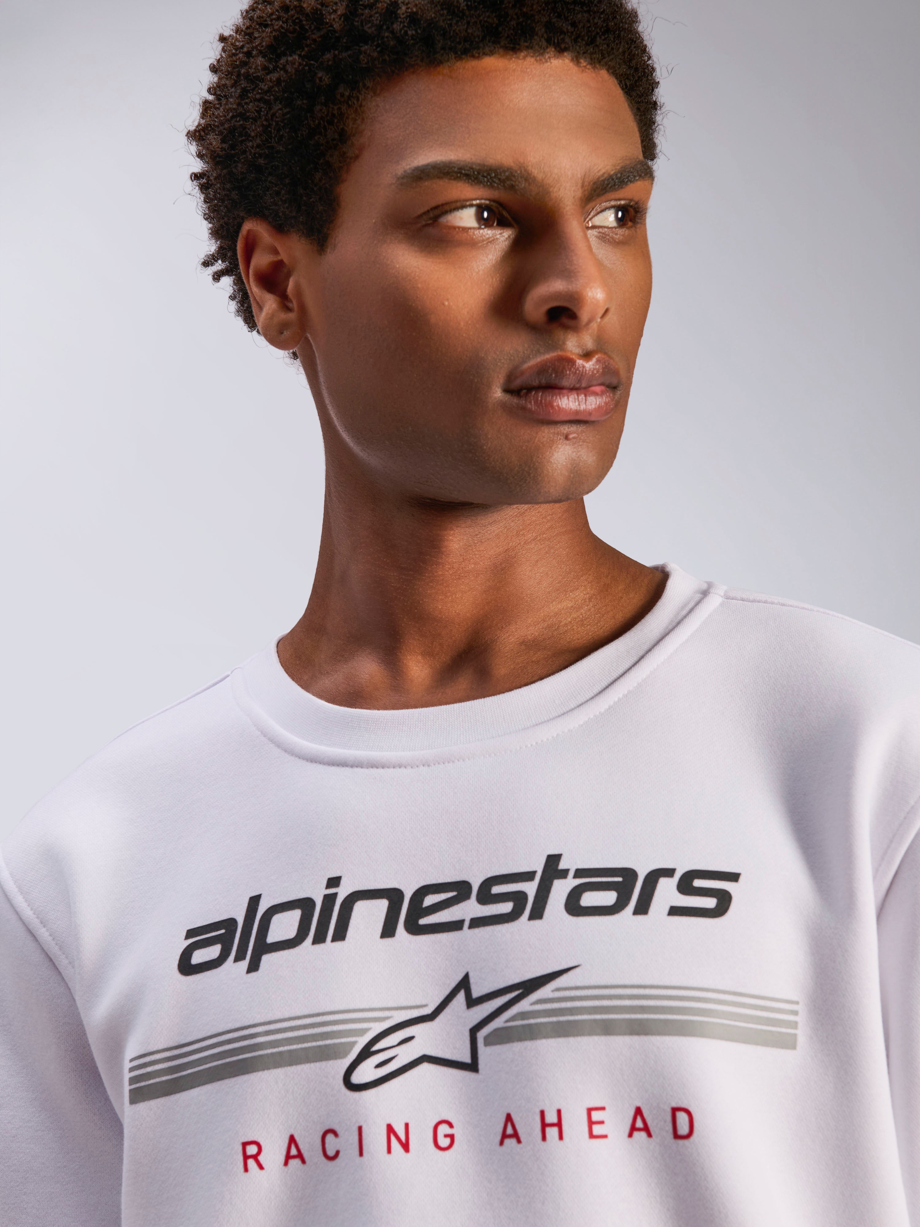 Alpinestars Bettern Crew, witte fleece crewneck, zwart Alpinestars logo met grijze horizontale strepen en rode 'Racing Ahead' tekst, casual motorsport-geïnspireerde streetwear