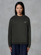Alpinestars Essentials Ageless Crew, premium crewneck sweatshirt, Off Black, featuring a small white Alpinestars logo on the chest, casual streetwear style worn by a model with dark jeans