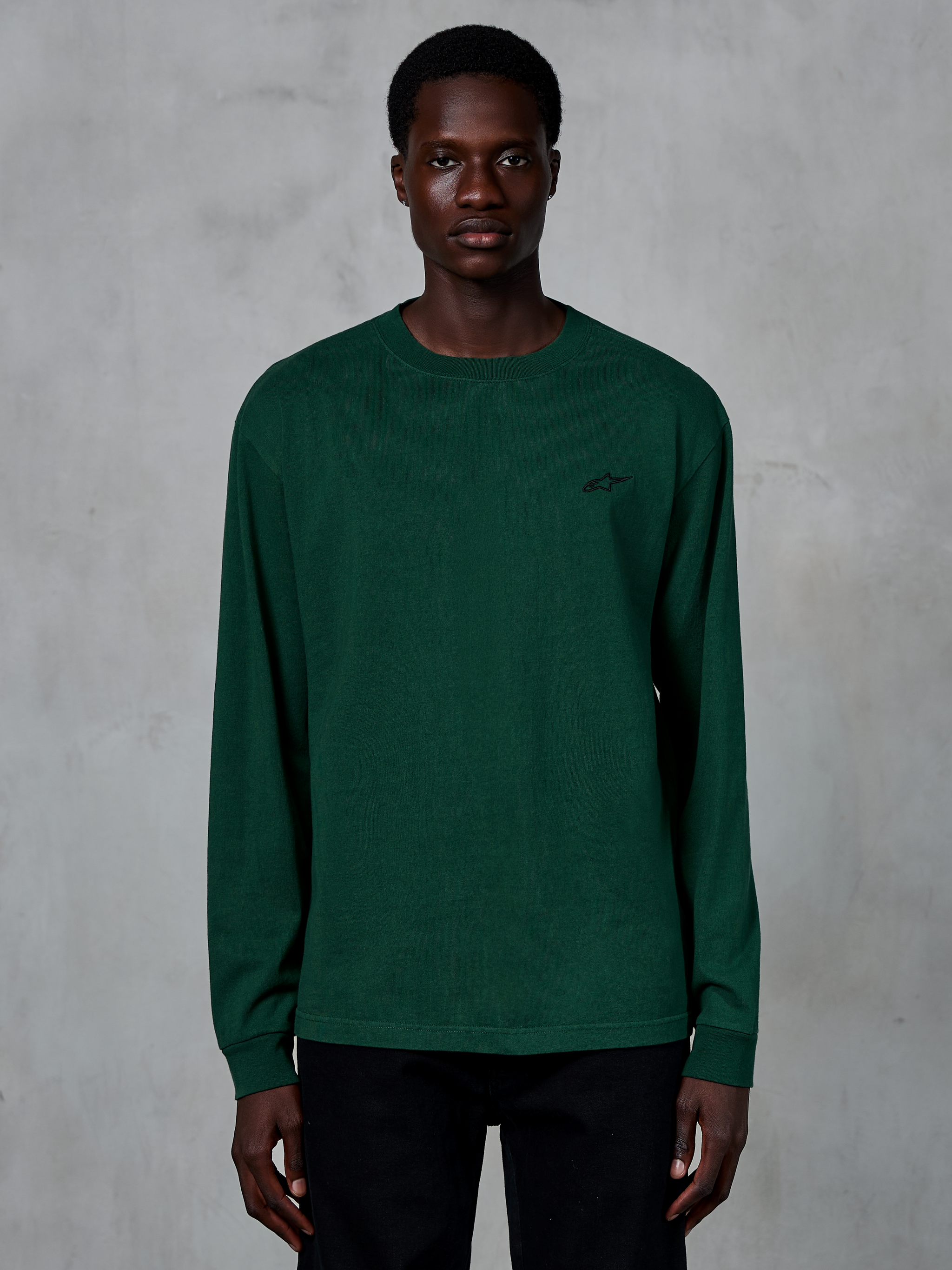 Alpinestars Essentials Ageless LS Tee, T-shirt met lange mouwen, Pine Green, gedragen door model, klein zwart logo op de borst, casual streetwear, 100% biologisch katoen met stone wash afwerking