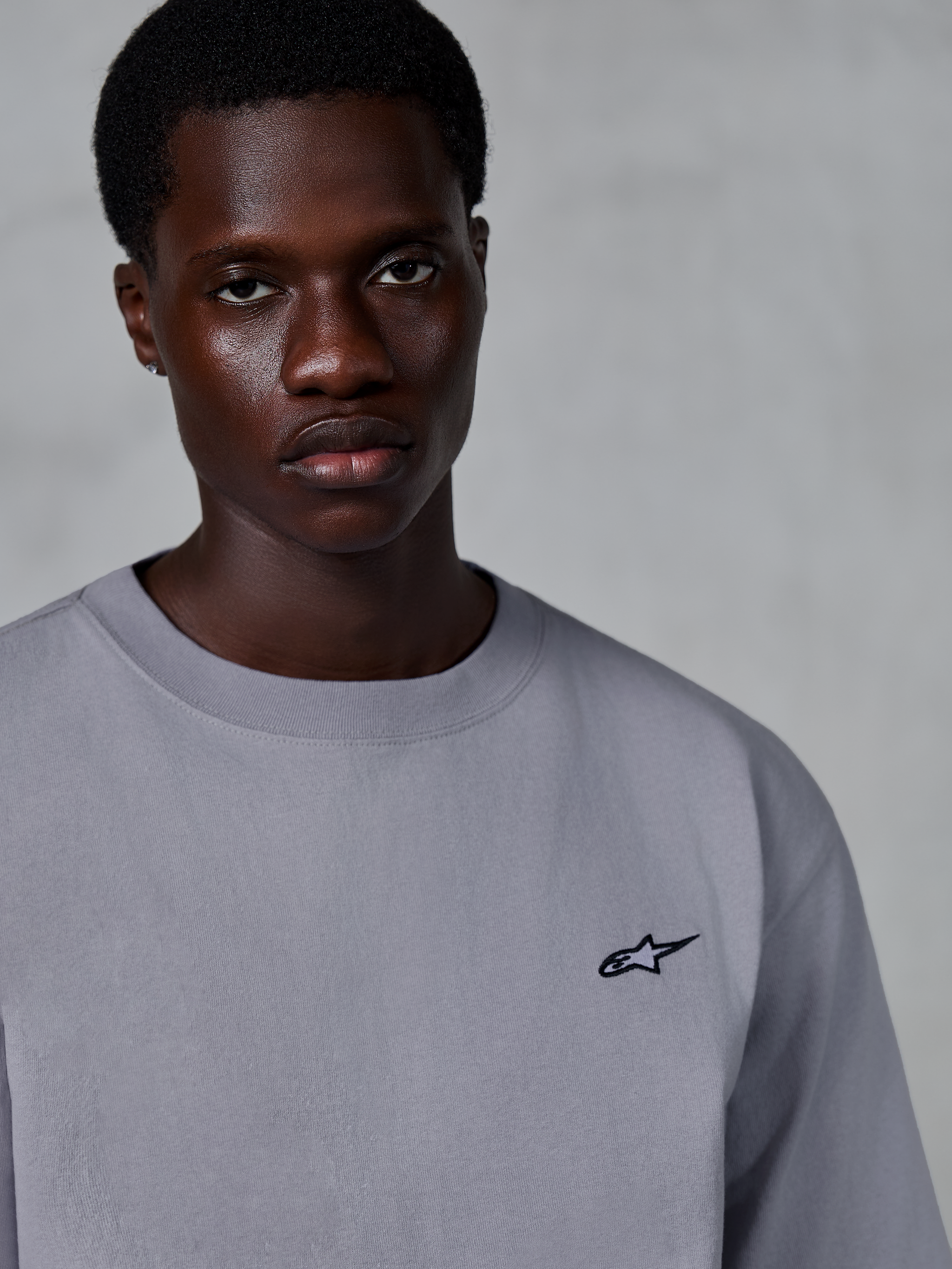 Alpinestars Essentials Ageless SS Tee, Short Sleeve T-Shirt, Silver, featuring a small black star logo on the chest, worn by model, casual lifestyle streetwear