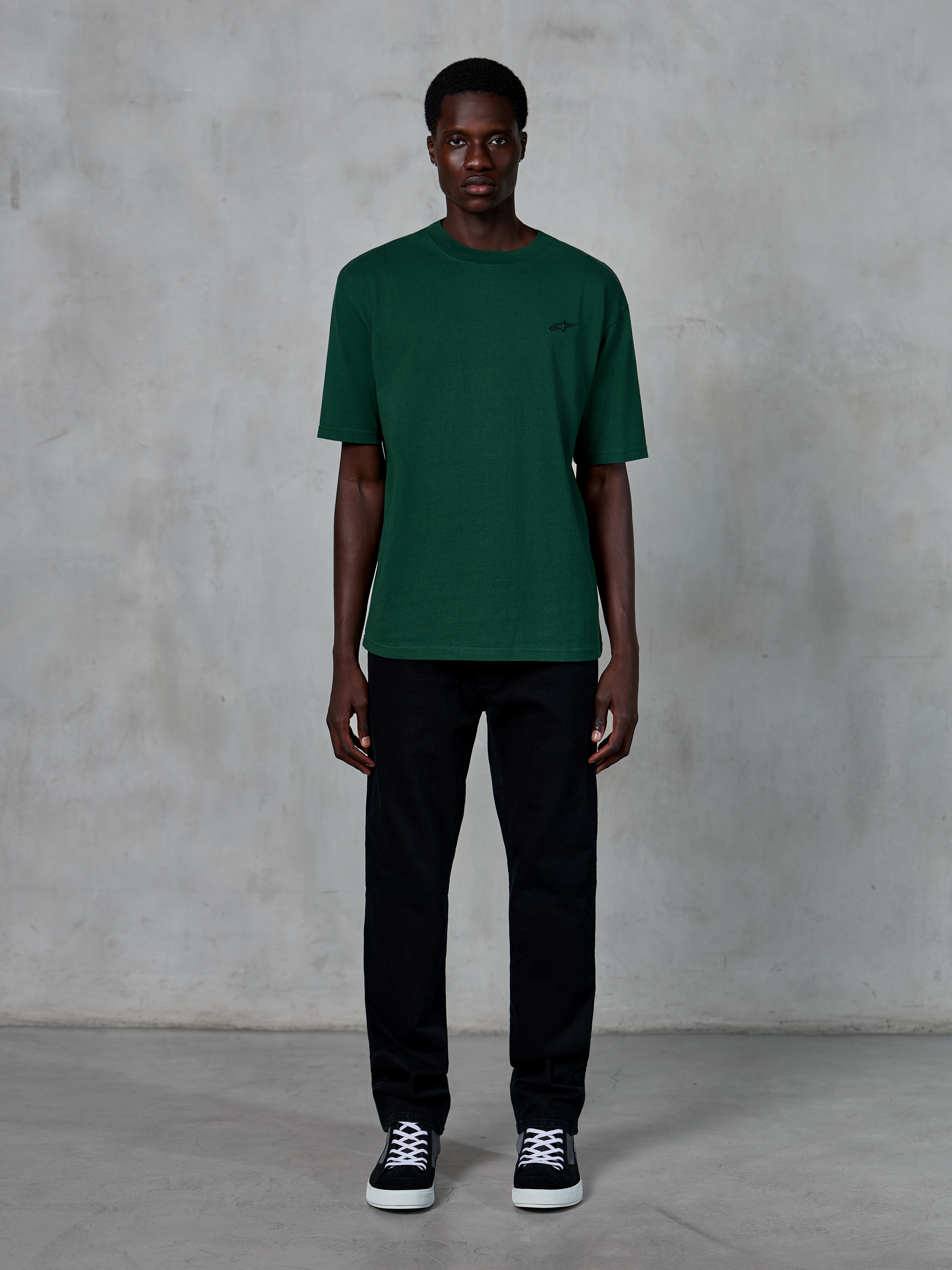 Alpinestars Essentials Ageless SS Tee, T-shirt met korte mouwen, Pine Green, voorzien van een subtiel zwart logo op de borst, gedragen door een model met zwarte broek en sneakers, casual lifestyle streetwear met een ontspannen pasvorm