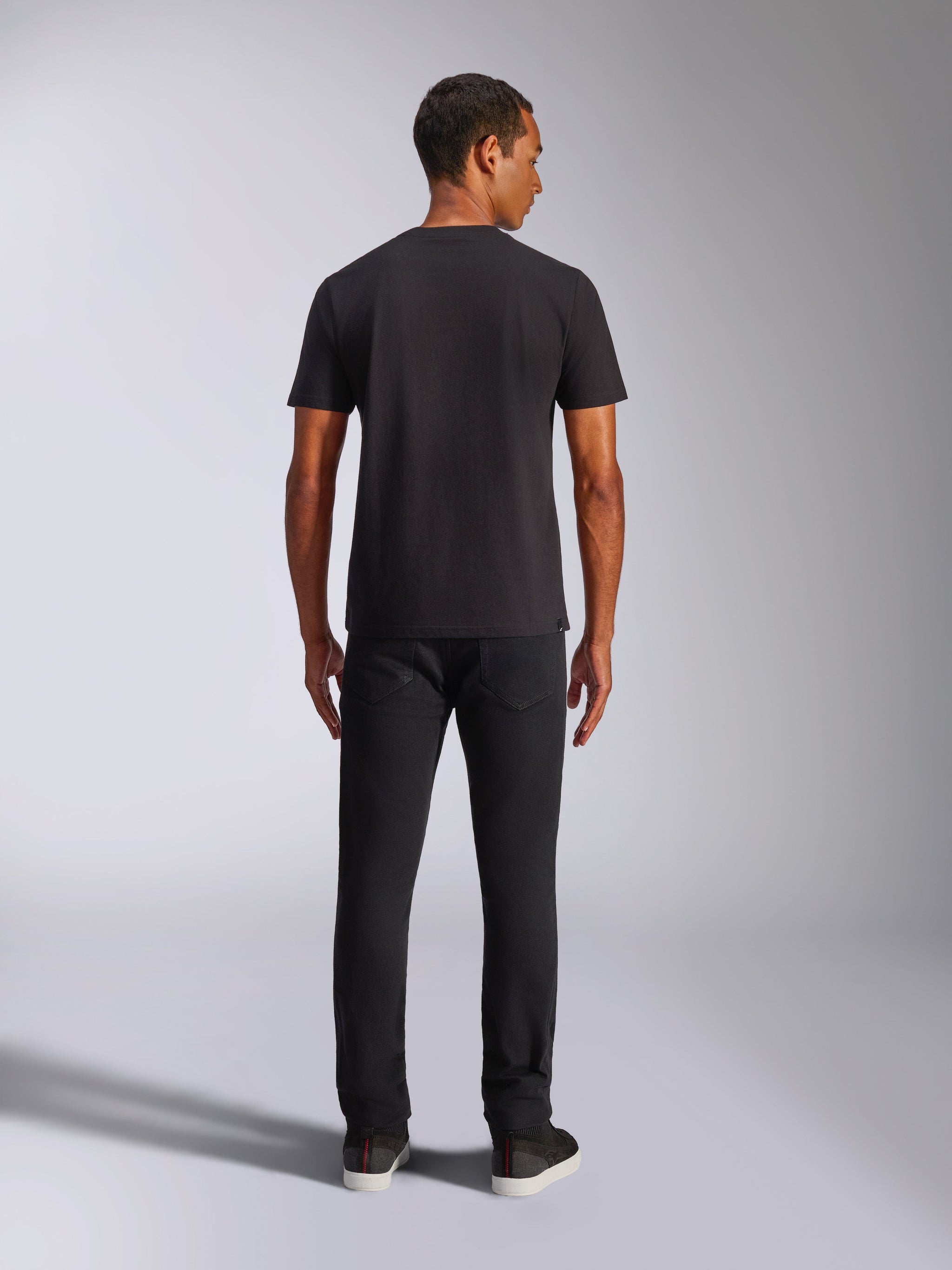 Alpinestars Shaded CSF Tee, T-shirt met korte mouwen, zwart, achteraanzicht op model met zwarte broek, casual motorsport-geïnspireerde streetwear