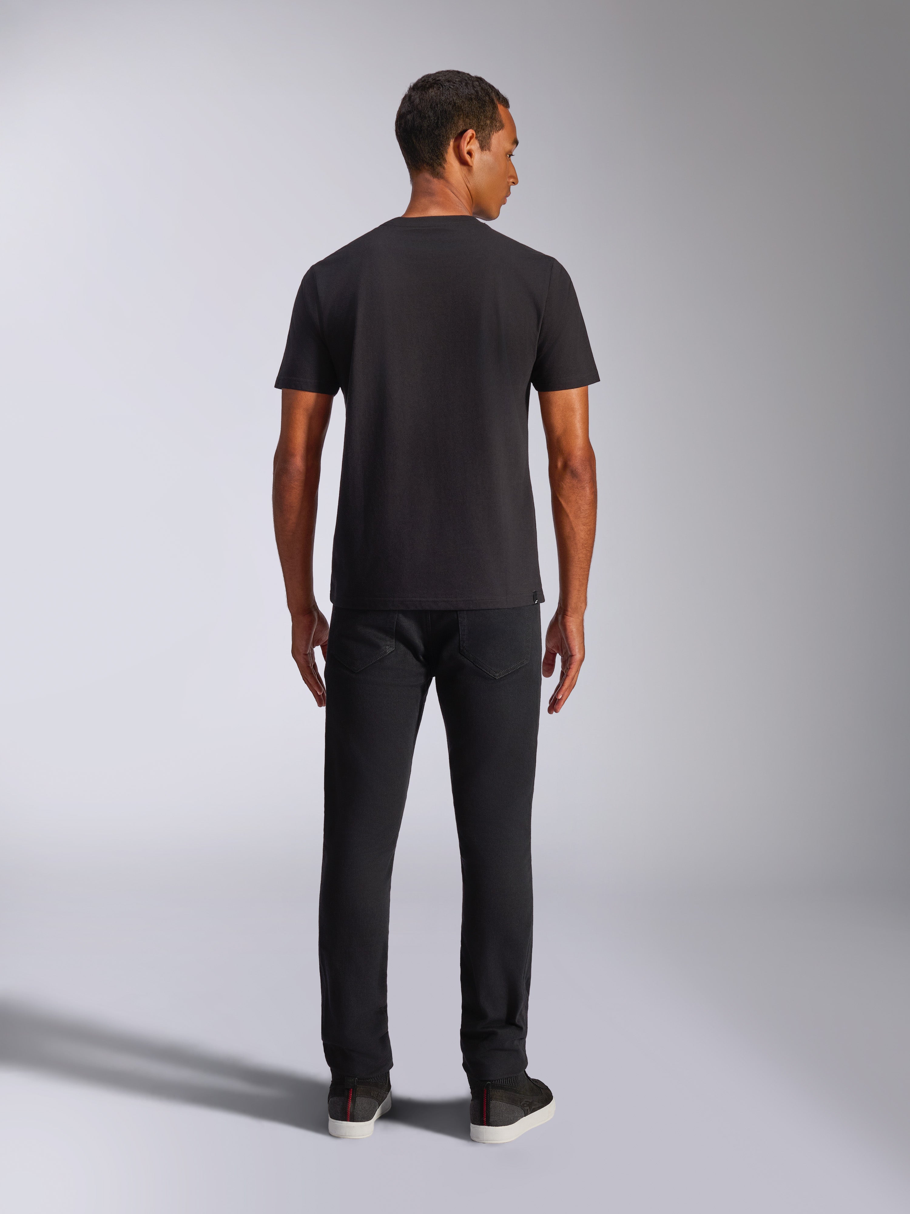 Alpinestars Shaded CSF Tee, T-shirt met korte mouwen, zwart, achteraanzicht op model met zwarte broek, casual motorsport-geïnspireerde streetwear