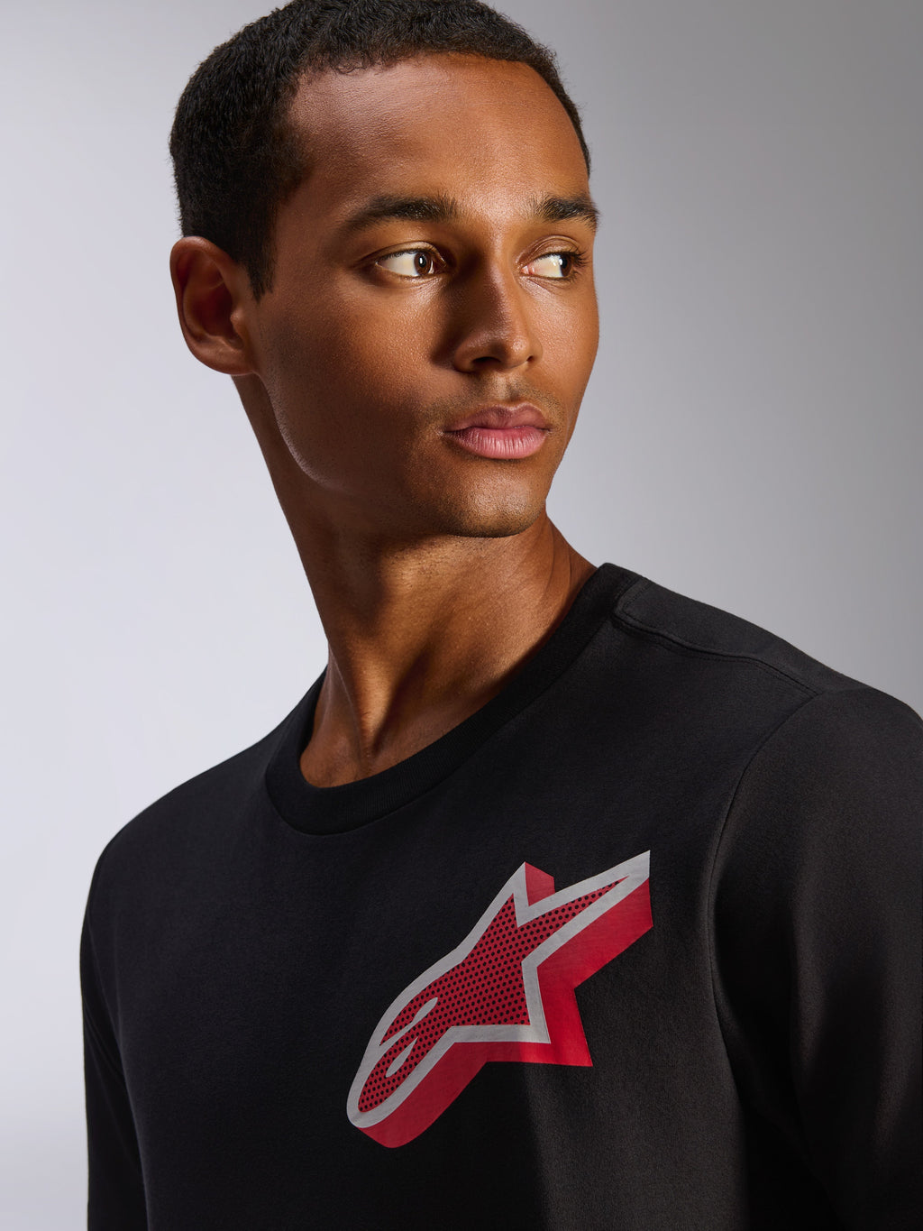 Alpinestars Shaded CSF Tee, T-shirt met korte mouwen, zwart, met een rood en wit gradient folie Astars-logo op de borst, casual op de motorsport geïnspireerde kleding gedragen door een mannelijk model