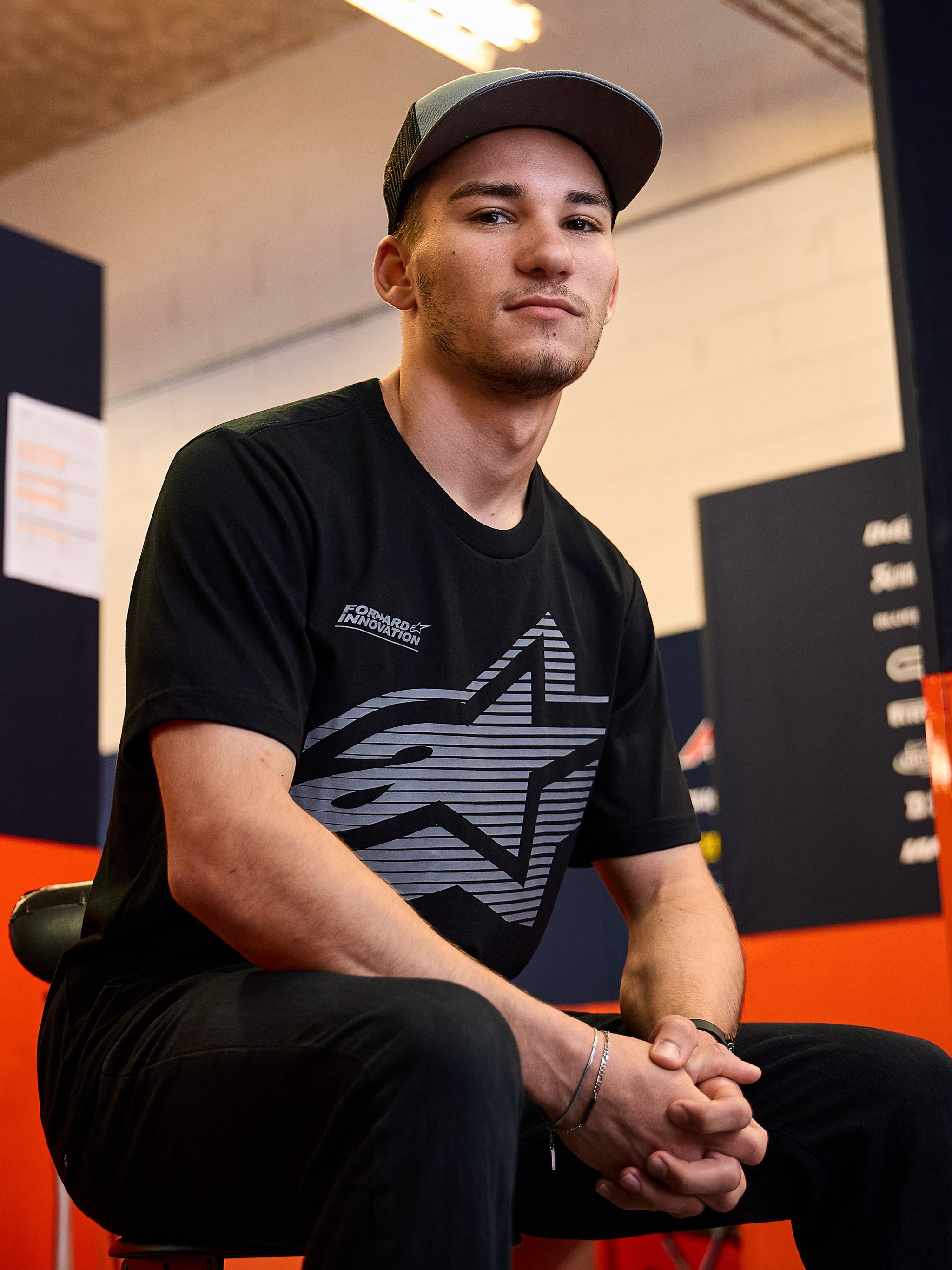 Alpinestars Fasting CSF Tee, T-shirt met korte mouwen, zwart, groot grijs geometrisch sterlogo met Forward Innovation tekst, gedragen door een man in een informele motorsportomgeving, lifestyle sportswear