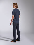 Alpinestars Fasting CSF Tee, T-shirt met korte mouwen, marineblauw, achteraanzicht op model, gecombineerd met een donkere denim broek en zwarte sneakers, casual motorsport-geïnspireerde streetwear