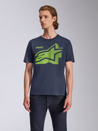 Alpinestars Fasting CSF Tee, T-shirt met korte mouwen, marineblauw, groot limegroen geometrisch Astars-logo, gedragen door model met donkere jeans, casual motorsport streetwear