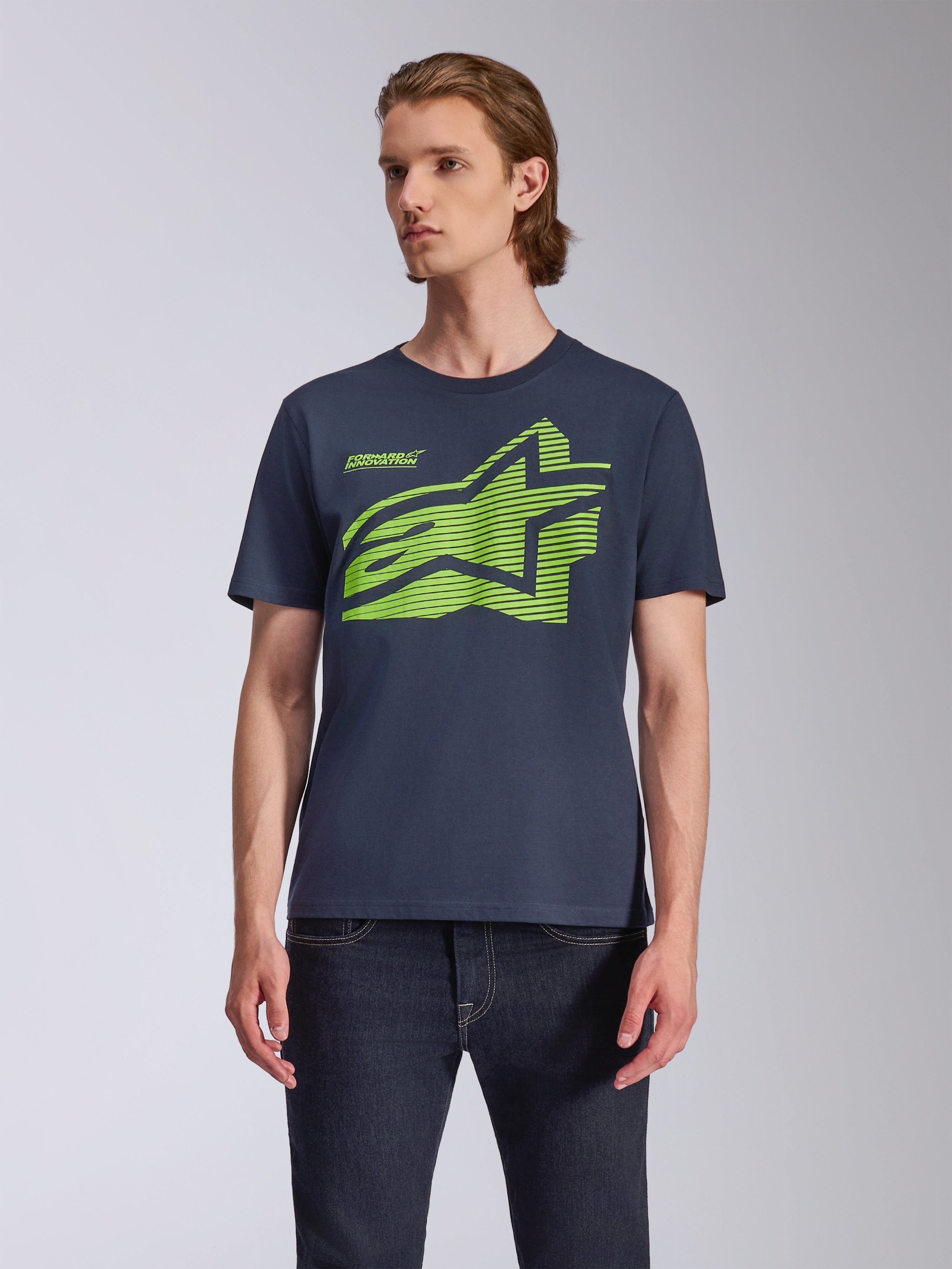 Alpinestars Fasting CSF Tee, T-shirt met korte mouwen, marineblauw, groot limegroen geometrisch Astars-logo, gedragen door model met donkere jeans, casual motorsport streetwear
