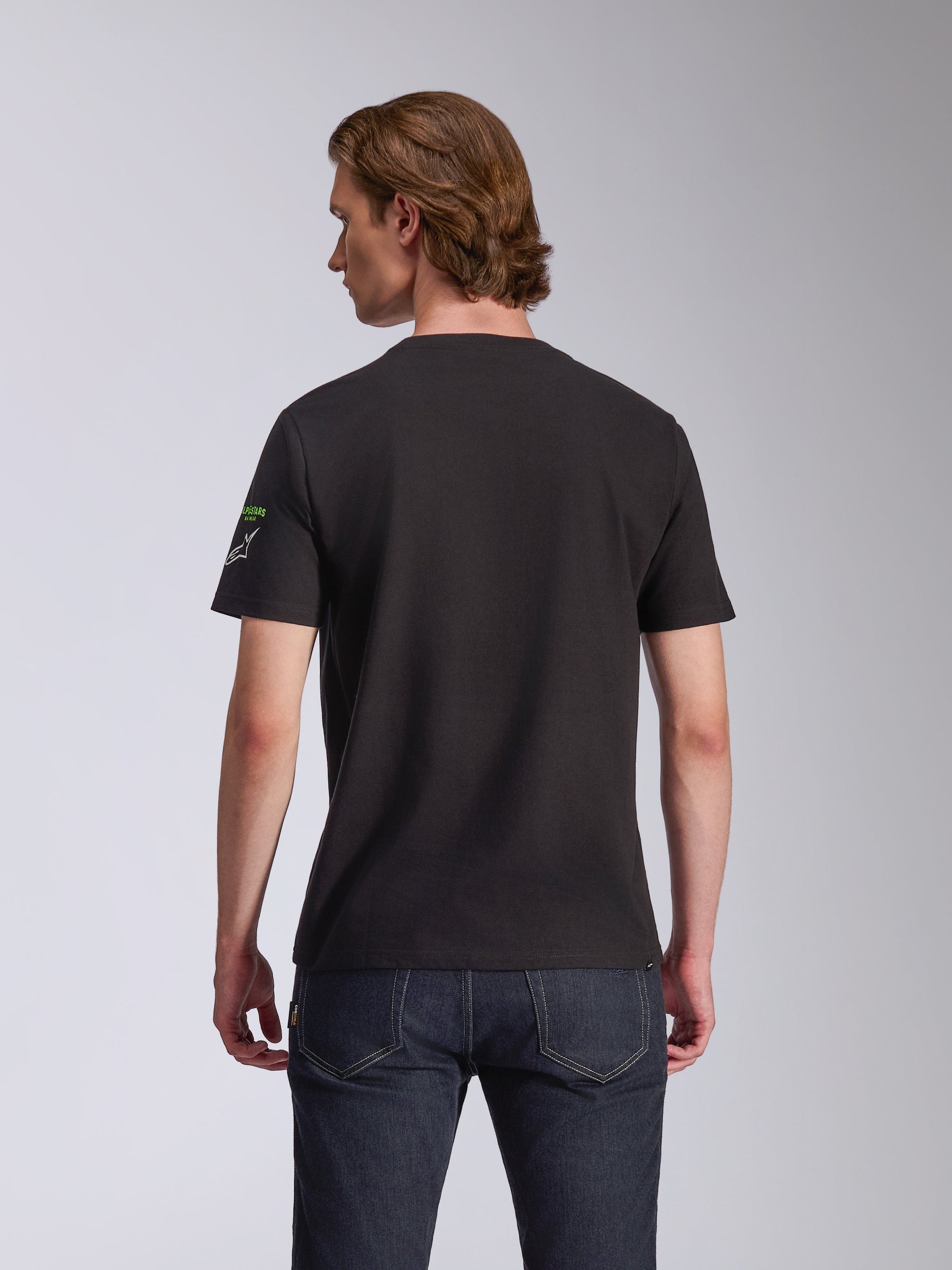 Alpinestars Entitled CSF Tee, T-shirt met korte mouwen, zwart, achteraanzicht op model, klein wit en groen logo op de mouw, casual motorsport-geïnspireerde streetwear
