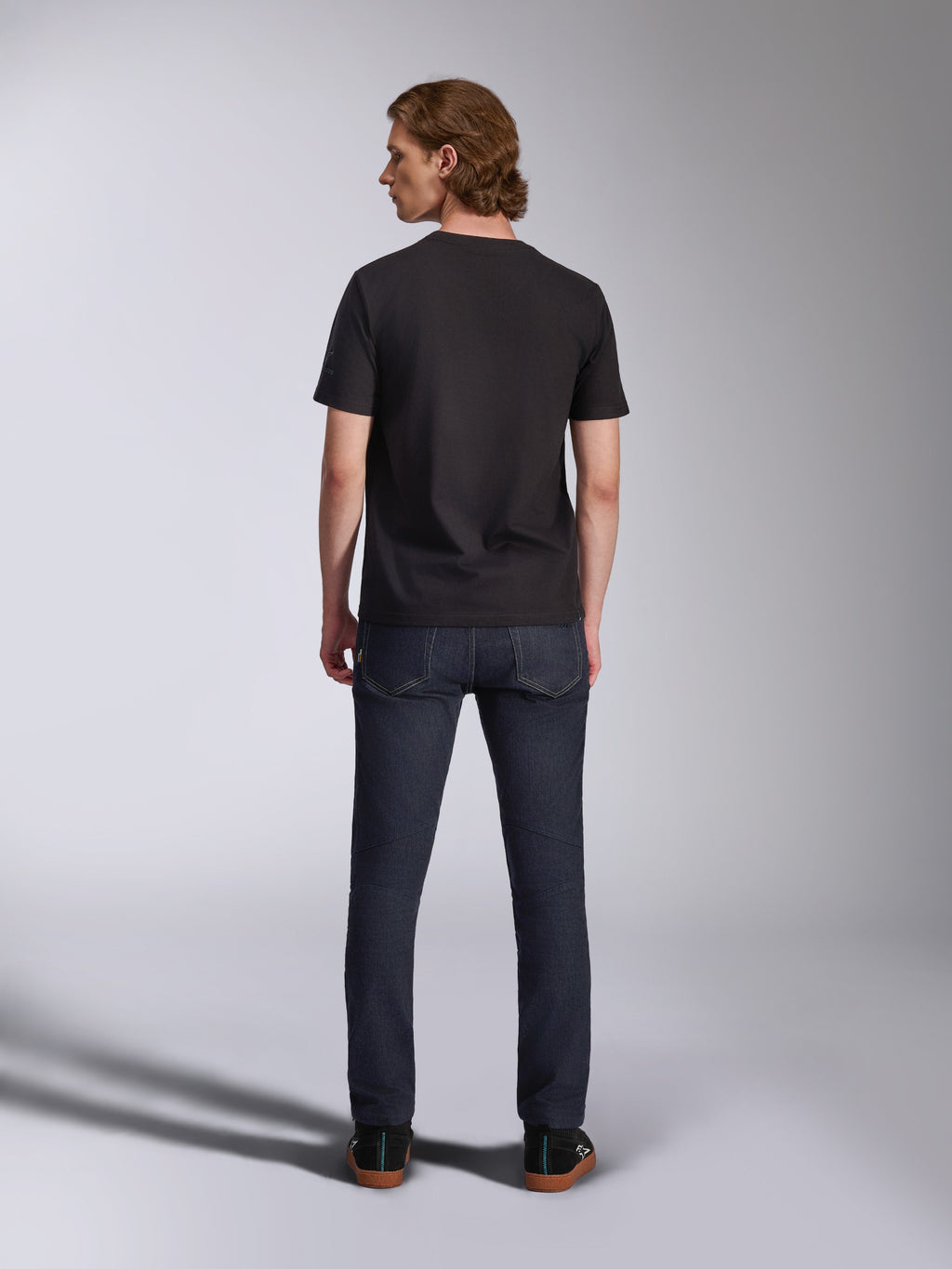 Alpinestars Global CSF Tee, zwart T-shirt met korte mouwen, achteraanzicht van een mannelijk model met een donkere denim jeans, casual streetwear geïnspireerd op de motorsport