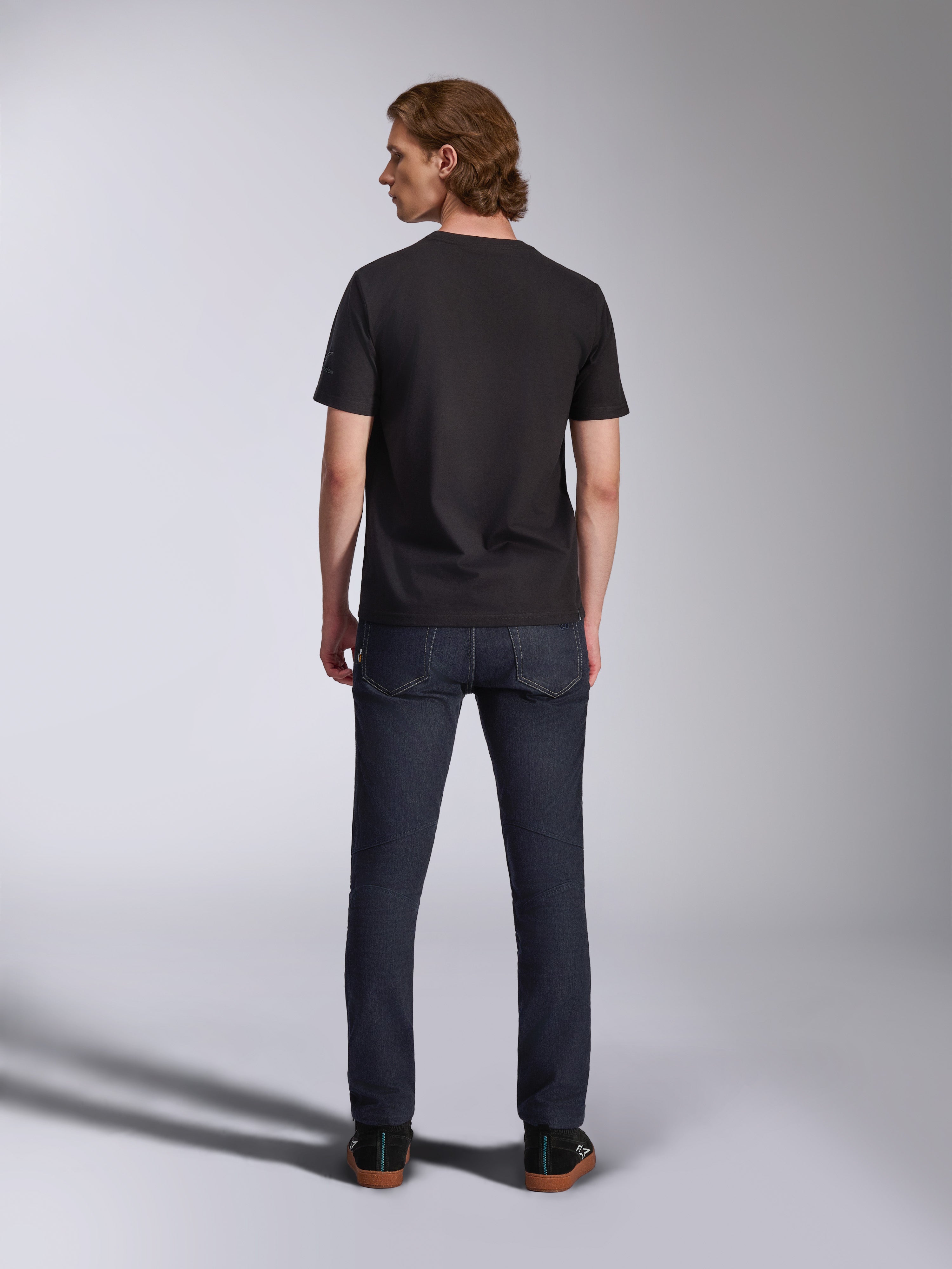 Alpinestars Global CSF Tee, zwart T-shirt met korte mouwen, achteraanzicht van een mannelijk model met een donkere denim jeans, casual streetwear geïnspireerd op de motorsport