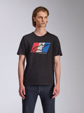 Alpinestars Global CSF Tee, T-shirt met korte mouwen, zwart, rood wit en blauw Ageless logo graphic, gedragen door mannelijk model met donkere jeans, casual motorsport streetwear