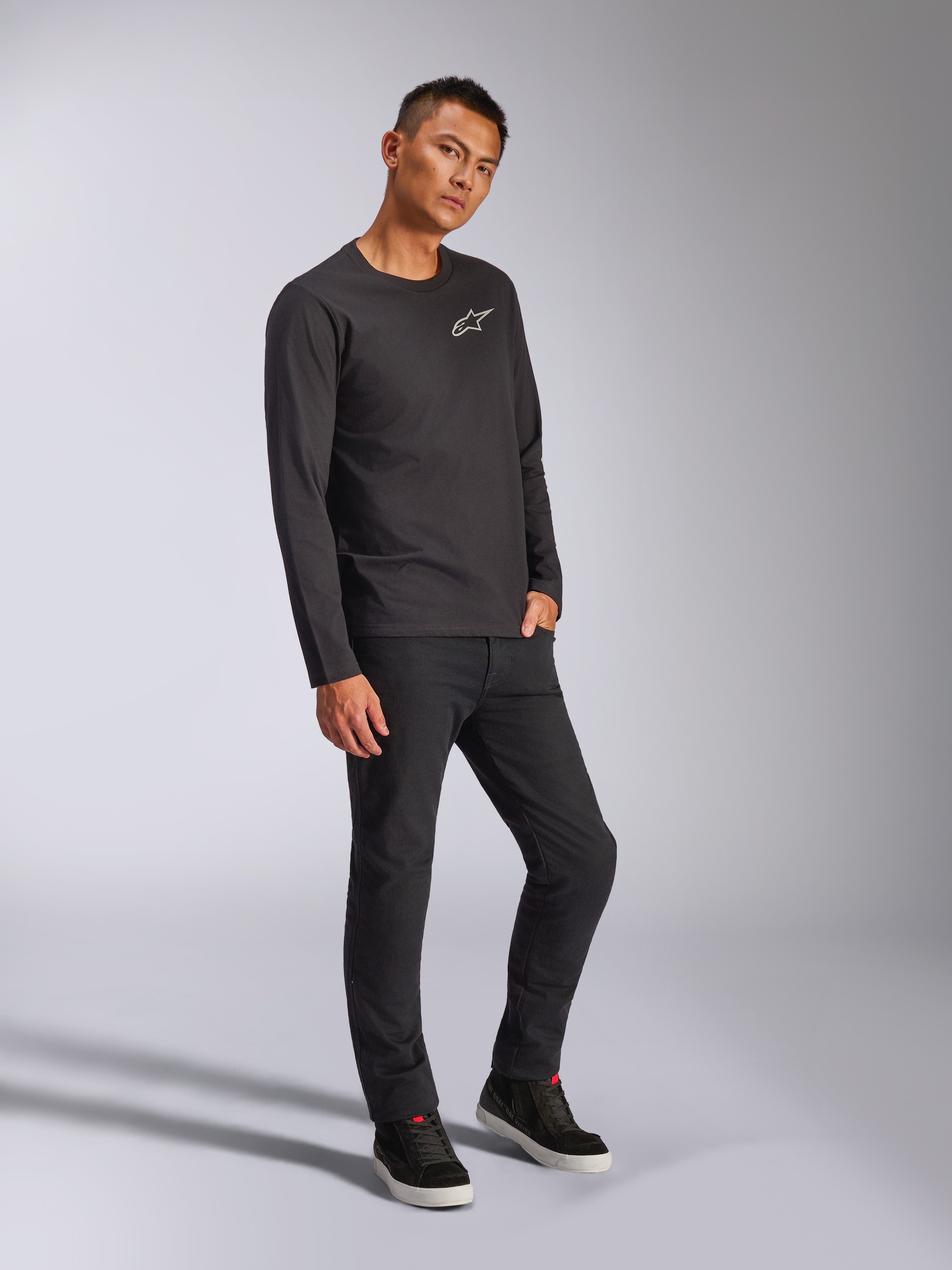 Alpinestars Trackside CSF Tee, Long Sleeve T-Shirt, Black, white Astars logo on chest, worn by model with black pants and sneakers, casual motorsport-inspired streetwear