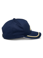 Alpinestars Ascension Snapback pet, zijaanzicht, marineblauw met goudkleurige en witte sutache-afwerking op de gebogen klep, gestructureerde kroon, casual motorsport hoofddeksel