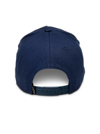 Alpinestars Ride Comp Snapback pet, donkerblauw, achteraanzicht met verstelbare plastic snapback-sluiting, klein zwart logolabel, gestructureerde kroon van katoenen keperstof, casual motorsport-geïnspireerde hoofdbedekking