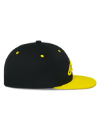 Alpinestars Thickness Snapback pet, zijaanzicht, zwarte kroon met Hi-Vis gele platte klep en ventilatiegaatjes, 3D-geborduurd logo op de voorkant, casual motorsport-geïnspireerde pet