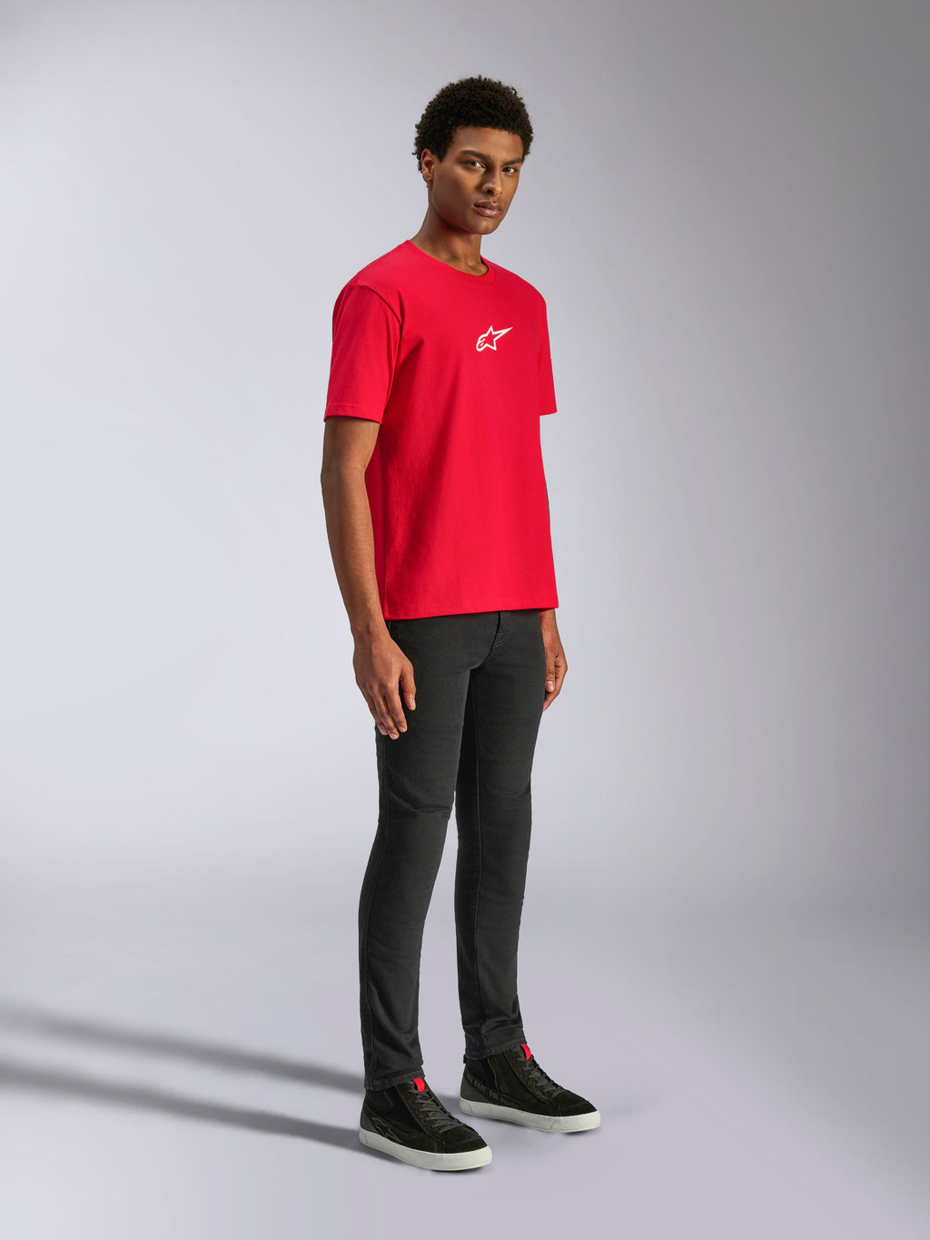 Alpinestars Frontal CSF Tee, T-shirt met korte mouwen, rood, wit sterlogo op de borst, gedragen door een model met zwarte broek en zwarte sneakers, casual motorsport performance streetwear