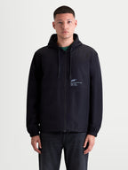 Alpinestars Speeder Resolve Windbreaker jas, lichtgewicht sportswear voor heren op een model, zwart, windbestendige constructie met meshvoering en verstelbare capuchon met 'One Goal. One Vision.' branding op de borst.