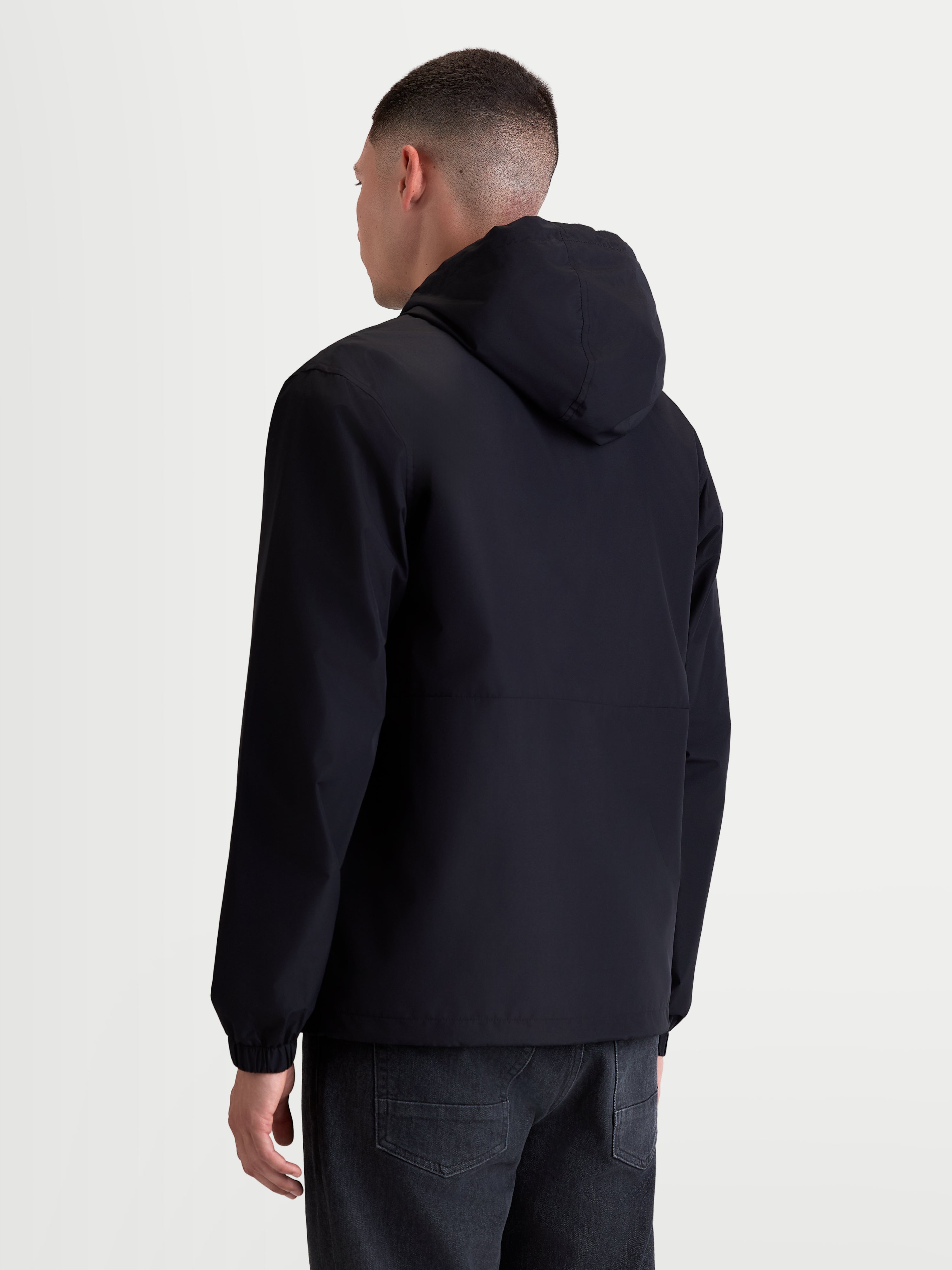 Alpinestars Speeder Resolve Windbreaker Jas, heren sportswear windbreaker voor stedelijk gebruik, zwart, achteraanzicht op model, lichtgewicht en ademende textielconstructie met een verstelbare capuchon.