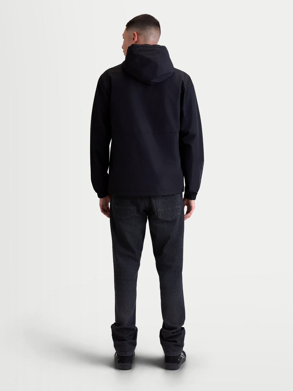 Alpinestars Speeder Resolve Windbreaker Jas, zwarte lichtgewicht jas voor stedelijk gebruik, achteraanzicht op model, ademende constructie met meshvoering en verstelbare capuchon.