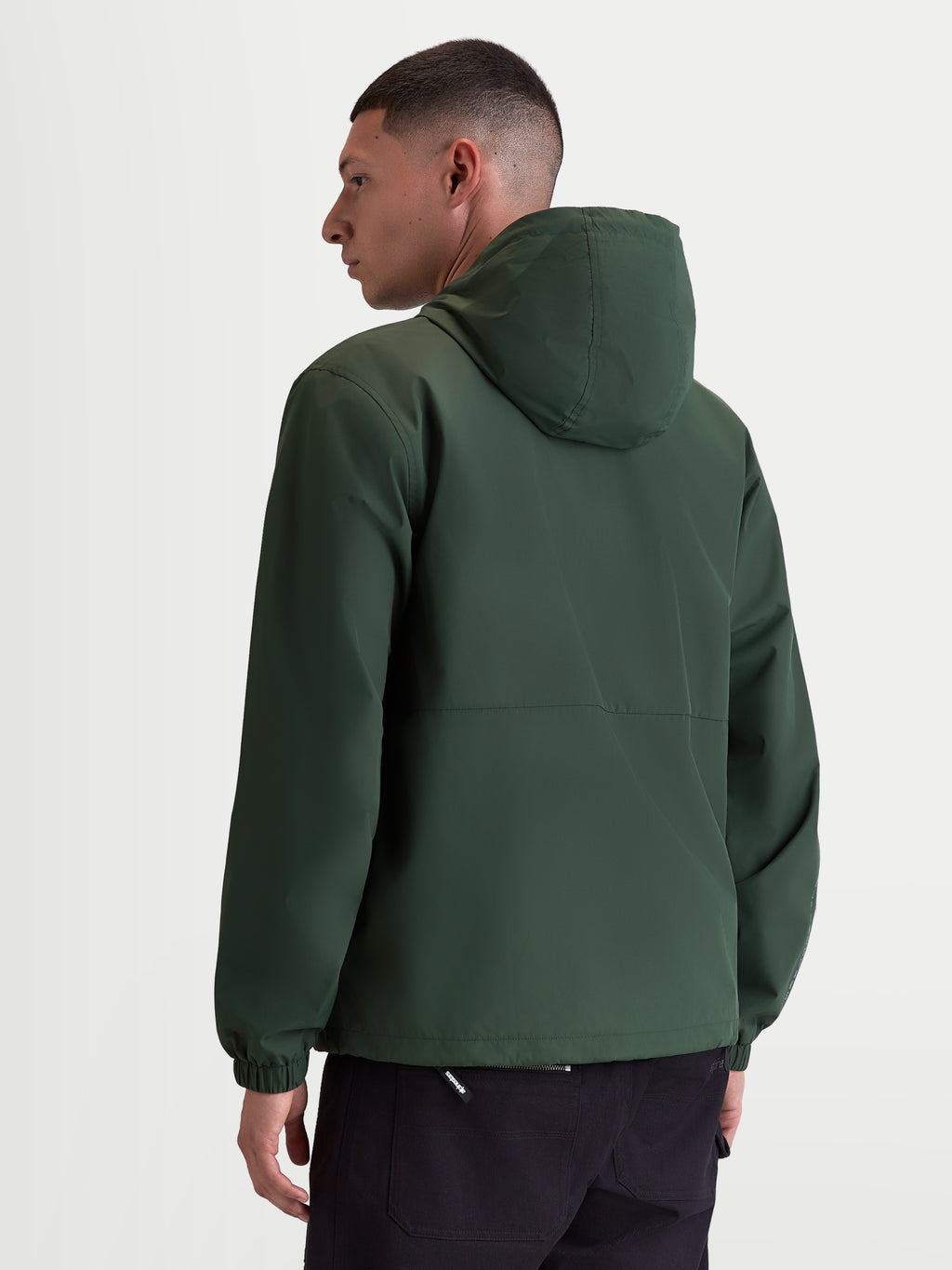 Alpinestars Speeder Resolve Windbreaker Jas, lichtgewicht sportswear met capuchon voor stedelijk gebruik, groen, winddicht 100% polyester met meshvoering, achteraanzicht op model met focus op het strakke rugontwerp en elastische manchetten.