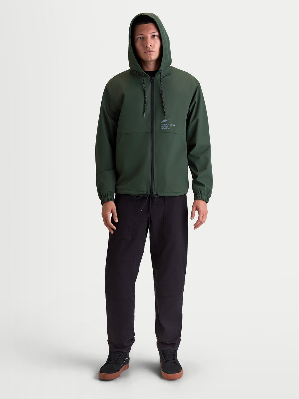Alpinestars Speeder Resolve windbreakerjas, lichtgewicht sportswearjas met capuchon, groen, 100% polyester, voorzien van verstelbare capuchon, omgekeerde spiraalrits en Alpinestars-branding op de borst, vooraanzicht op model.