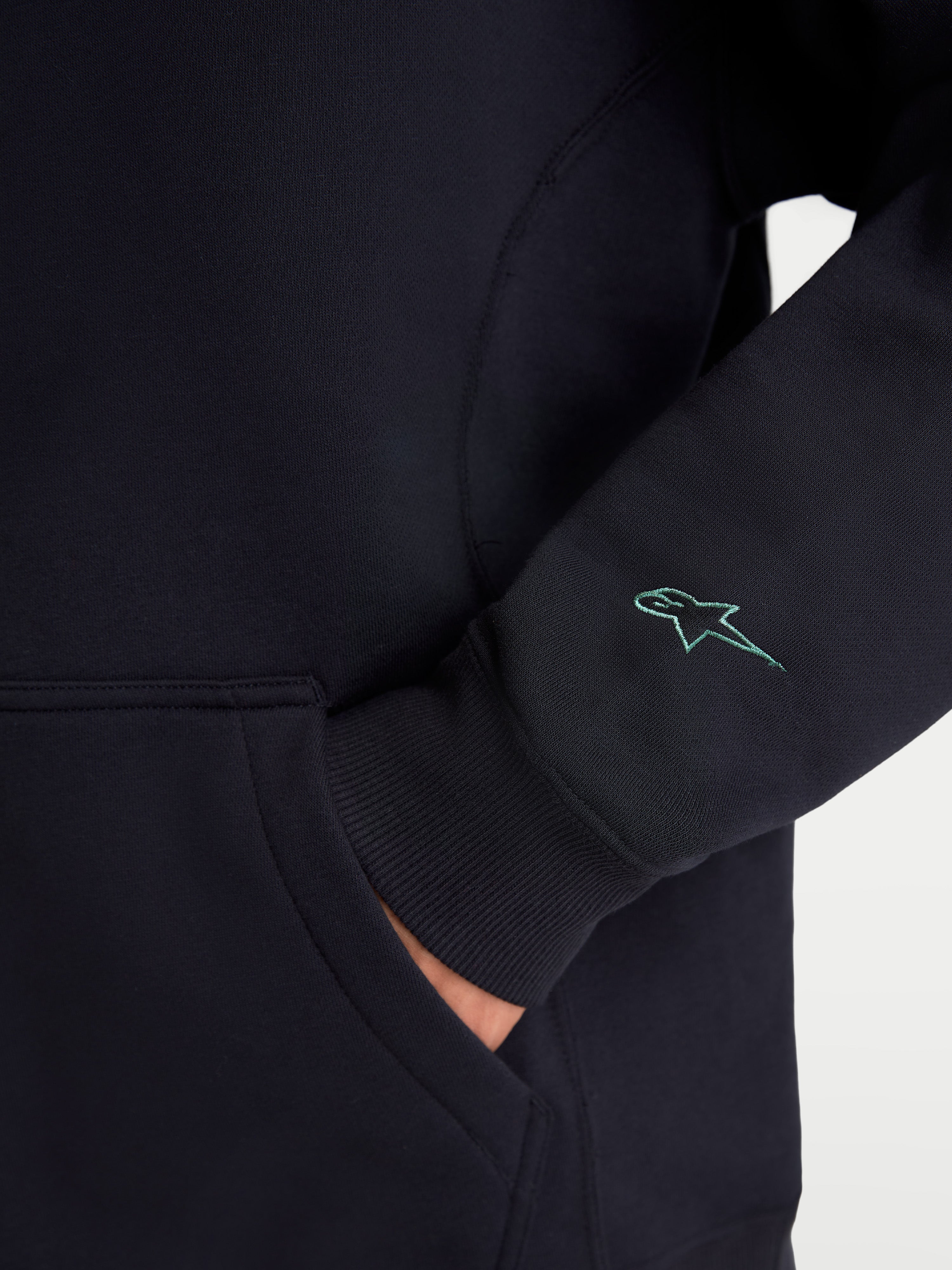 Alpinestars Guise Oversized Crew, sportswear fleece pullover, zwart, detail van het geborduurde Astars-logo op de mouw, geribde manchetten en kangoeroezak, mix van katoen en gerecycled polyester, relaxte oversized pasvorm.