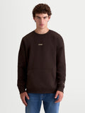 Alpinestars Guise Oversized Crew, bruine sportswear fleece pullover, unisex relaxte pasvorm getoond op model, katoen en gerecycled polyester, met kangoeroezak en geborduurd Alpinestars-logo op borst en mouw voor een premium motorsport-geïnspireerde look.