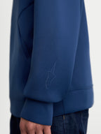 Alpinestars Datrix hoodie, premium sportswearhoodie in blauw, close-up van de mouw met een tonaal HD Alpinestars-logo, gemaakt van tri-blend dubbelzijdige fleecestof voor dagelijks comfort.