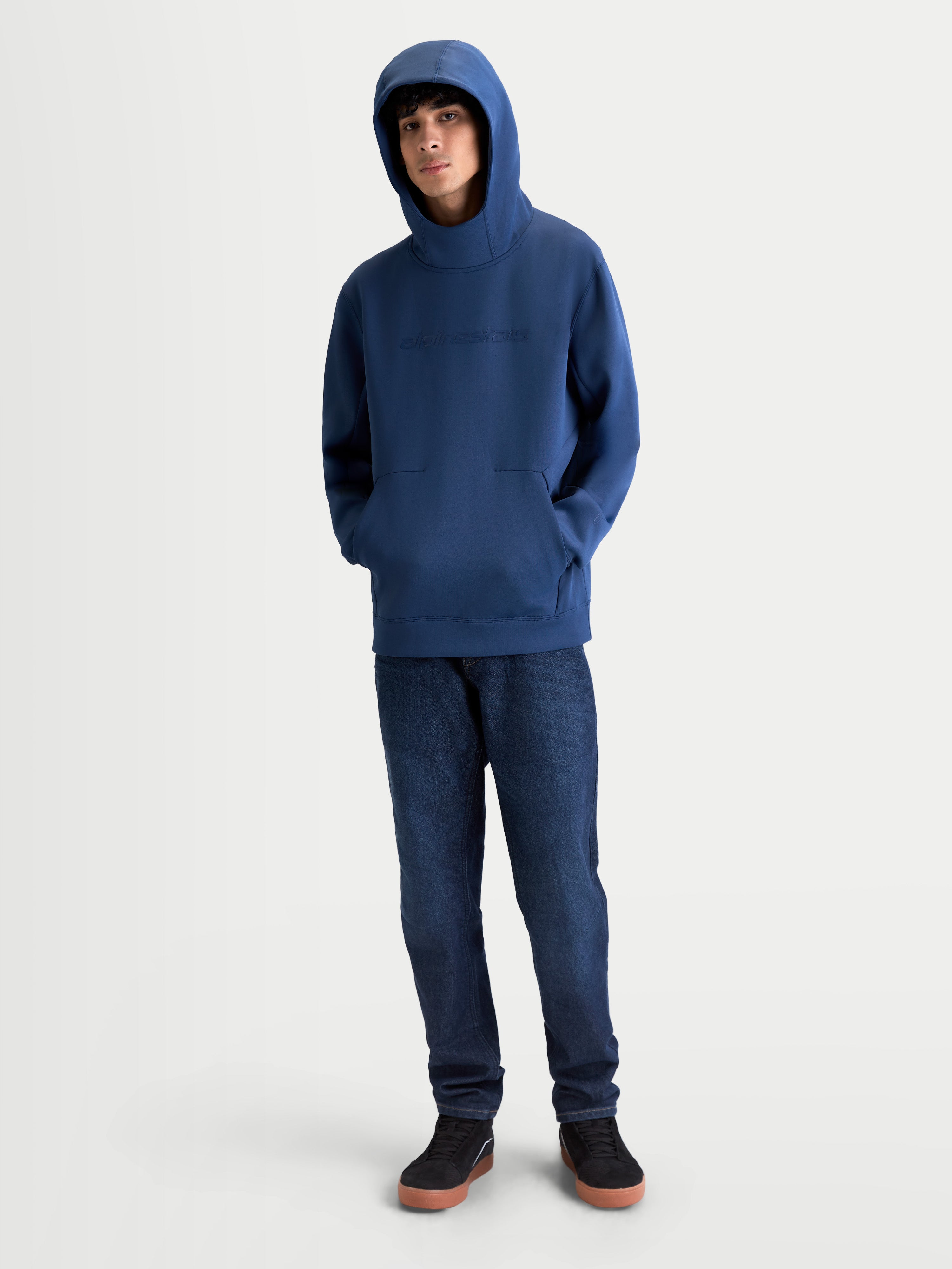 Alpinestars Datrix hoodie, motorsport-geïnspireerde sportswear pullover, steel blue blauw, premium tri-blend fleece, voorzien van een tonaal HD-logo op de borst en een capuchon met meshvoering, gedragen door een model.