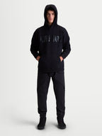 Alpinestars Shaw Oversized Hoodie, relaxte sportswear-pullover voor heren en dames, zwart, met getextureerd woordlogo op de borst, kangoeroezak en zelfgevoerde capuchon, katoen en gerecycled polyester fleece.