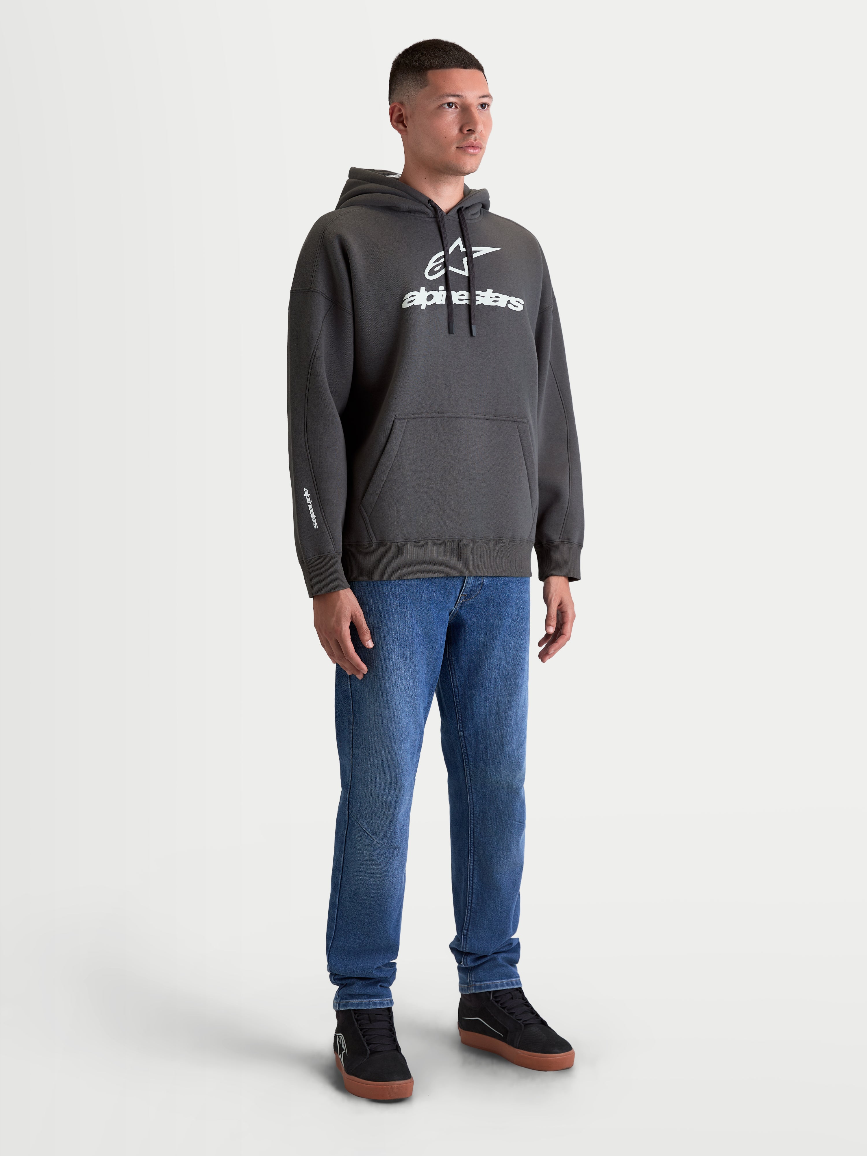 Alpinestars Prelude Oversized Hoodie, premium sportswear fleece pullover, grijs en wit, kangoeroezak, relaxte oversized pasvorm, wit puff-print logo, casual lifestyle look op model
