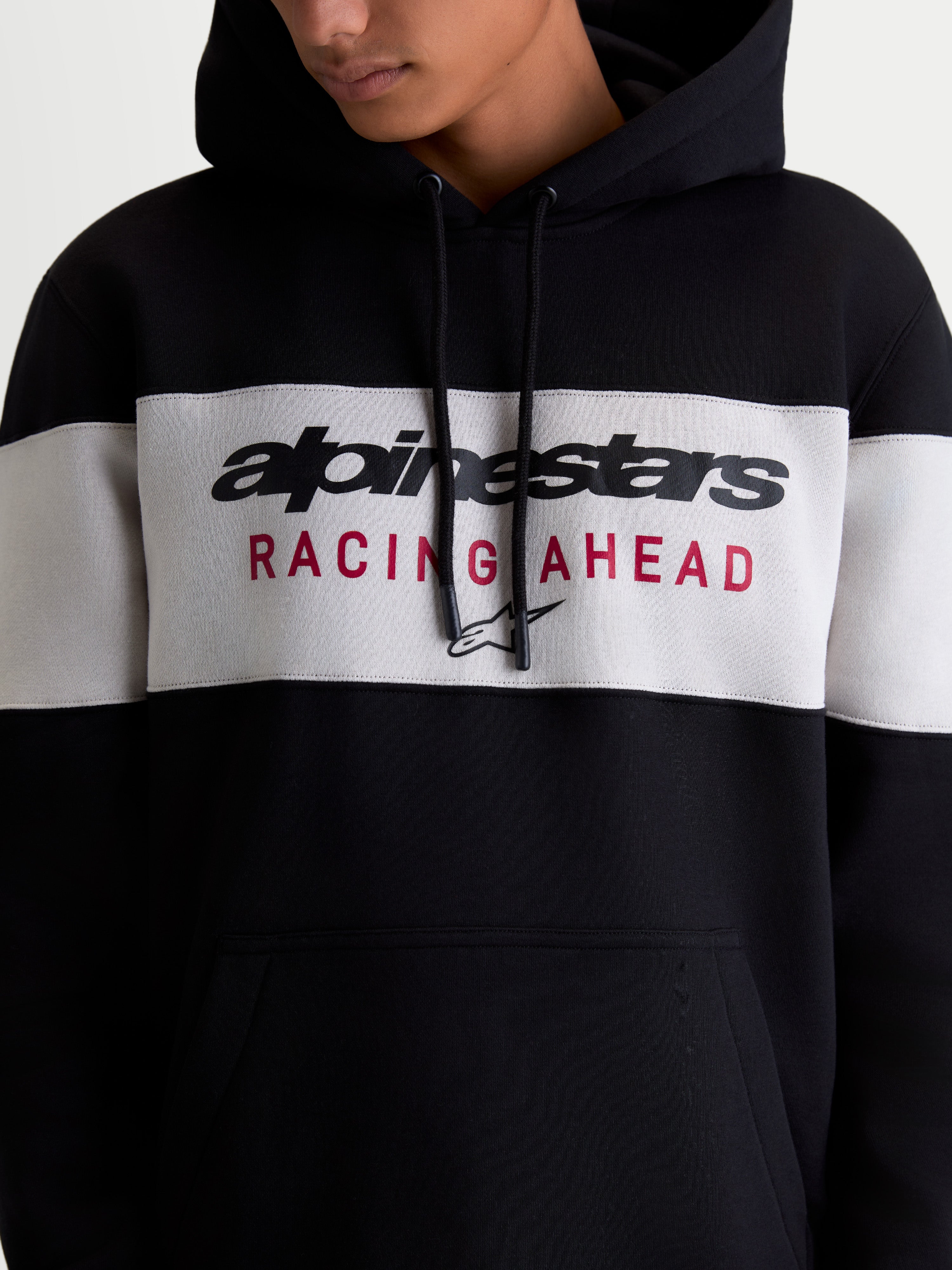 Alpinestars Cubic hoodie, sportswear pullover fleece, zwart en cementgrijs, kleurgeblokt ontwerp met Alpinestars woordlogo en Racing Ahead graphic op de borst, katoen en gerecycled polyester mix.