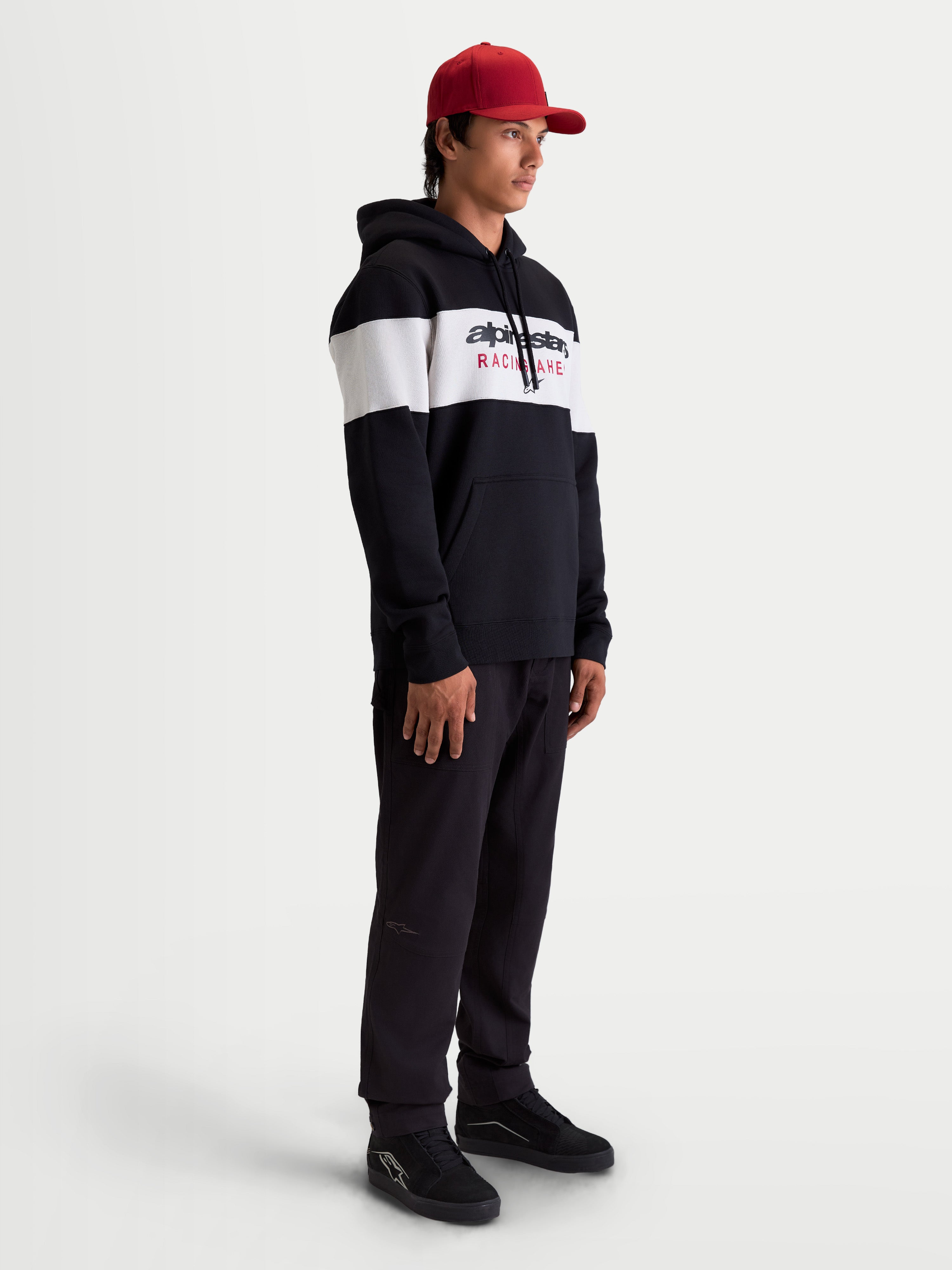 Alpinestars Cubic Hoodie, heren-sportswear pullover fleece hoodie, zwart en wit kleurgeblokt ontwerp met Alpinestars-logo op de voorkant, zachte katoenmix constructie, lifestyle-weergave op model.