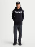 Alpinestars Velocifier hoodie, heren-fleece pullover voor casual gebruik, zwart met wit Astars-woordmerk op de borst en logo's op de schouders, premium katoenmix, getoond op model met bijpassende pet.