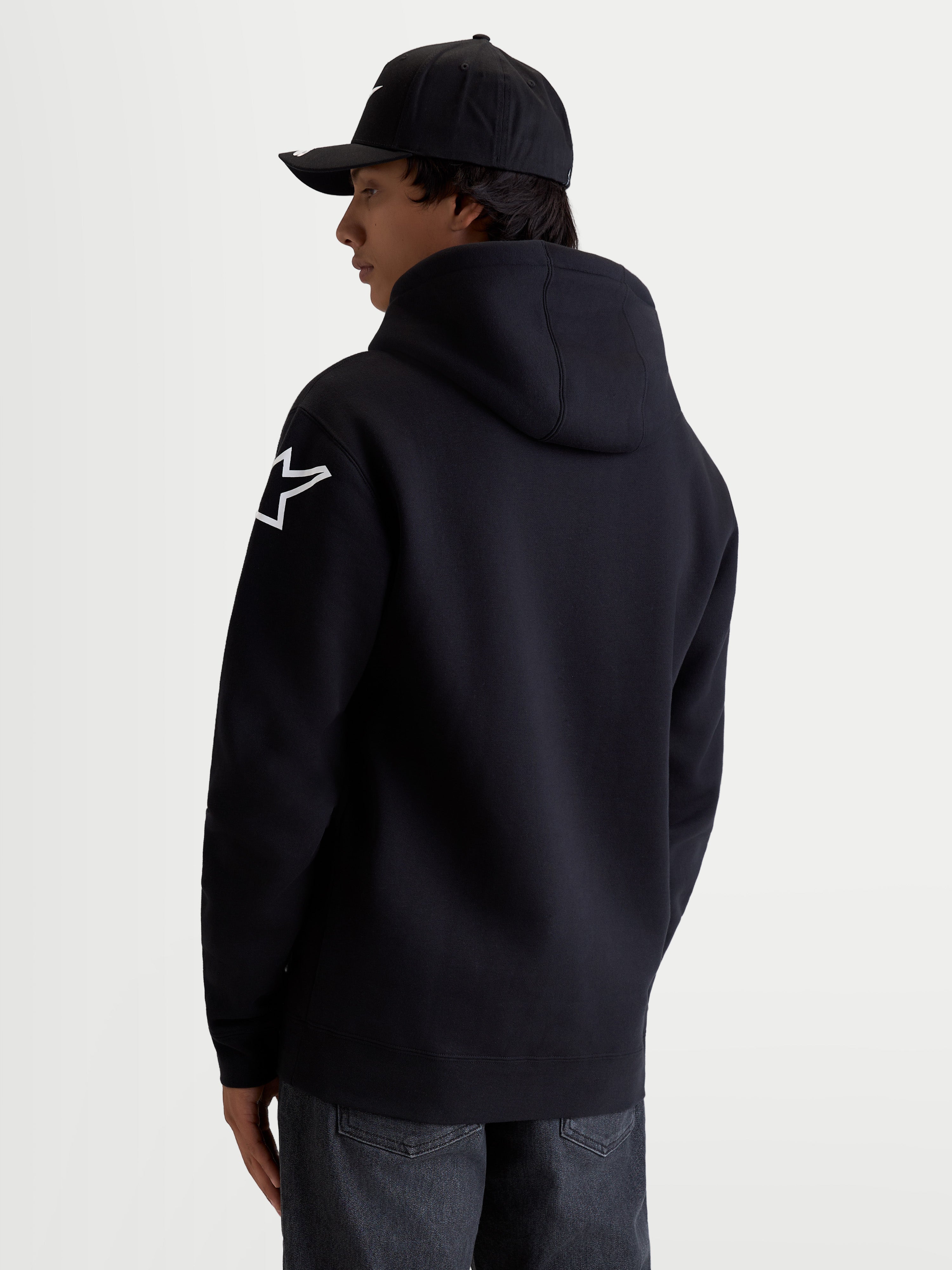 Alpinestars Velocifier Hoodie, herenpullover van fleece in zwart, katoen en gerecycled polyestermix met wit Astars-schouderlogo, gevoerde capuchon en ribboorden, casual sportswear voor motorsportliefhebbers, achteraanzicht op model