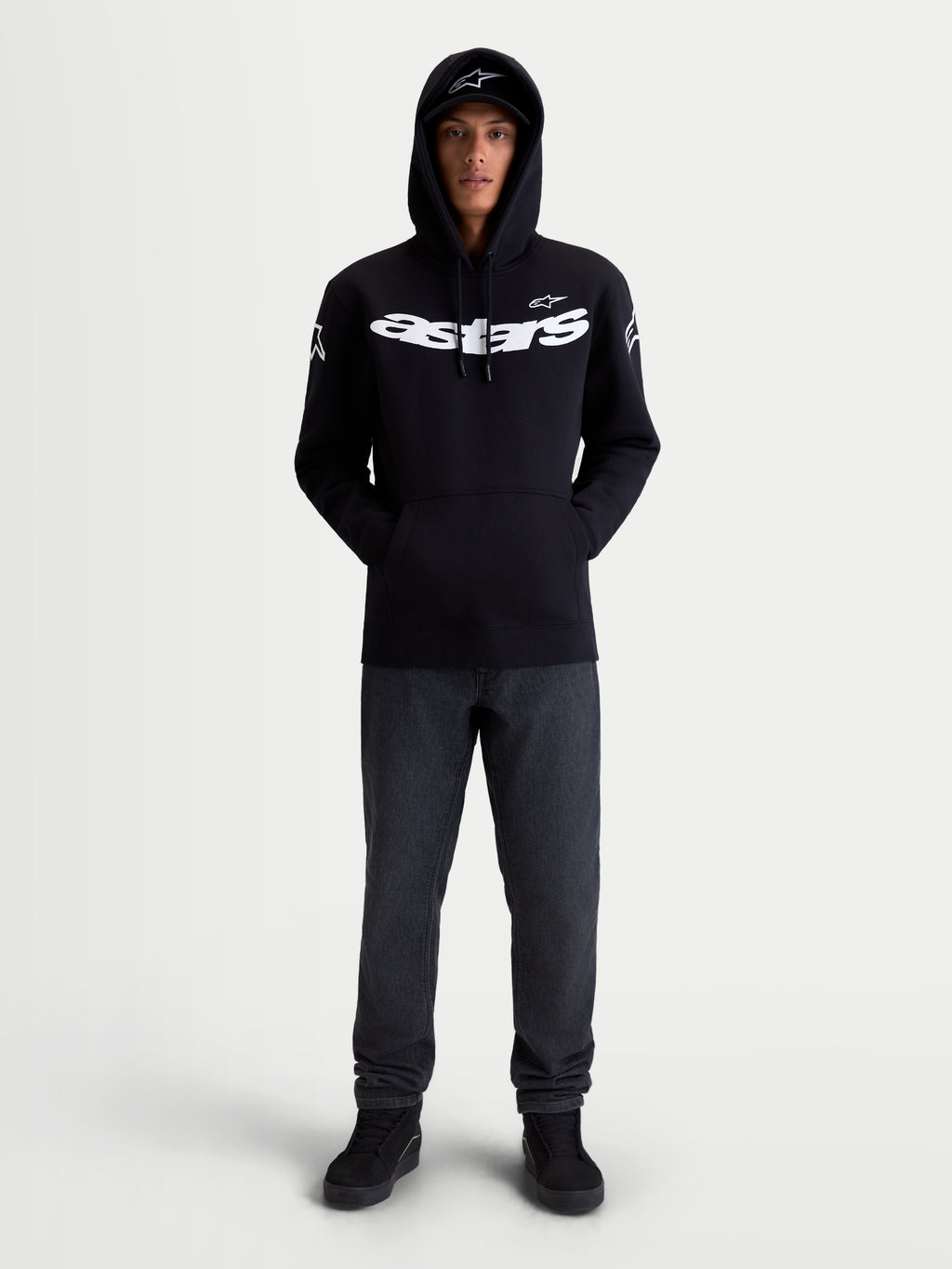 Alpinestars Velocifier hoodie, sportswear-fleecepullover voor motorsport, unisex, zwart en wit, mix van katoen en gerecycled polyester, voorzien van een opvallend Astars-woordmerk op de borst en logo's op de schouders, vooraanzicht op model voor casual vrijetijdskleding.