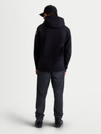 Alpinestars Velocifier hoodie, heren sportswear fleecepullover, zwart en wit, mix van katoen en gerecycled polyester, achteraanzicht op model met witte Alpinestars-logo's op de schouders en capuchon.